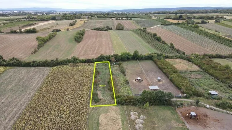 Luftaufnahme eines Grundstücks von 1015m² inmitten landwirtschaftlicher Felder mit klarer Markierung.