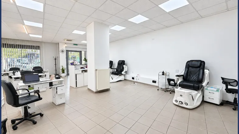 Geräumiger, heller Gewerberaum mit mehreren Behandlungsstühlen und Arbeitsplätzen, ideal für ein Nagelstudio.