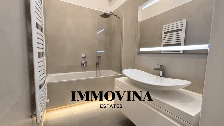 Modernes Badezimmer mit Badewanne, Regendusche, stilvollem Waschbecken und Handtuchheizkörper.