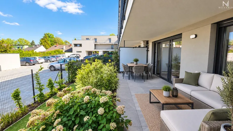 Geräumige Terrasse mit modernen Gartenmöbeln und Blick auf die grüne Umgebung.