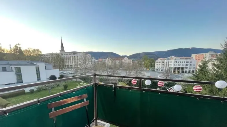 Balkon mit Blick auf die Stadt und die umliegenden Berge, ausgestattet mit einer Sitzgelegenheit.