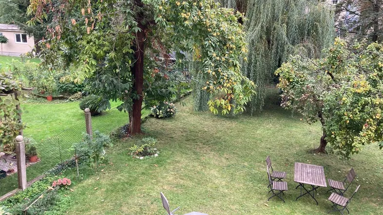 Großer Garten mit Rasenfläche, Obstbäumen und Sitzgelegenheiten für entspannte Stunden im Freien.