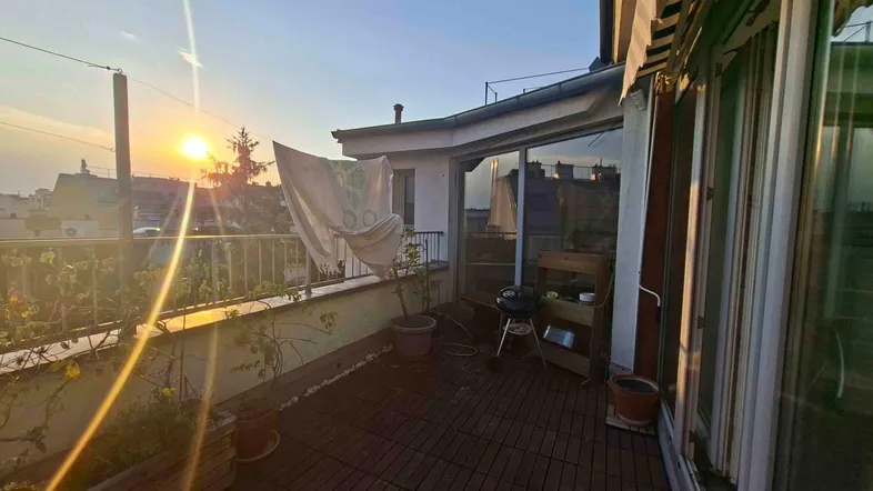 Geräumige Terrasse mit Holzboden, Pflanzen und Grill, ideal für entspannte Abende im Freien.