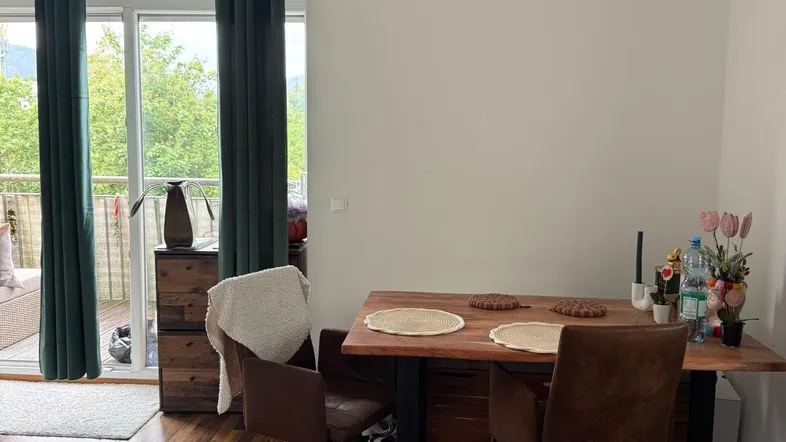Heller Essbereich mit Holztisch, bequemen Stühlen und direktem Zugang zum Balkon.