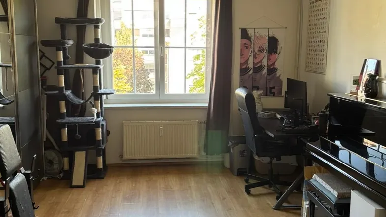 Geräumiger Wohnbereich mit Holzfußboden, Fenster und vielseitiger Nutzung als Arbeits- und Freizeitraum.