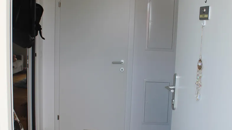 Heller Eingangsbereich mit Fliesenboden und Garderobe, der zu den Wohnräumen führt.