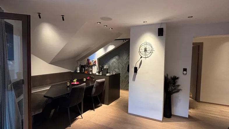 Geräumiger Wohn- und Essbereich mit offener Küche, Holzboden und Zugang zum Balkon.