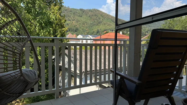 Geräumiger Balkon mit Hängesessel und Bergblick, ideal zum Entspannen im Freien.