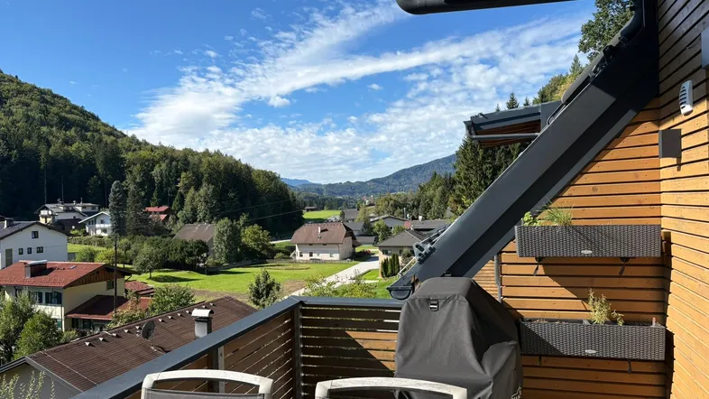 Geräumiger Balkon mit Sitzgelegenheiten und weitem Blick auf die umliegende Berglandschaft und das Tal.