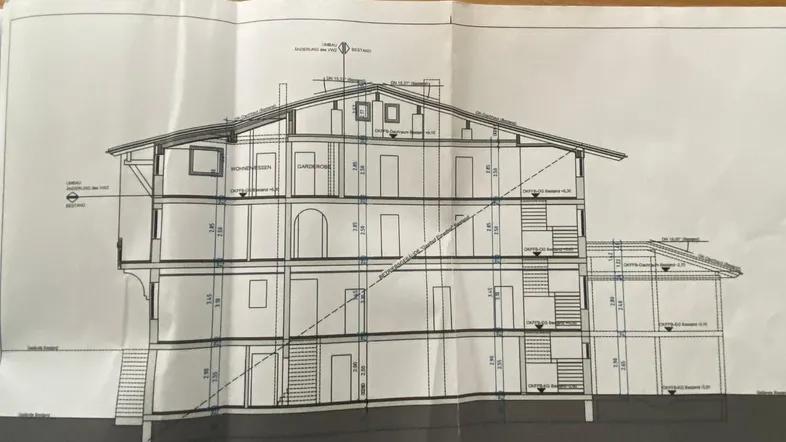 Architektonische Schnittzeichnung des Gebäudes, die die vertikale Struktur und Dachneigung zeigt.