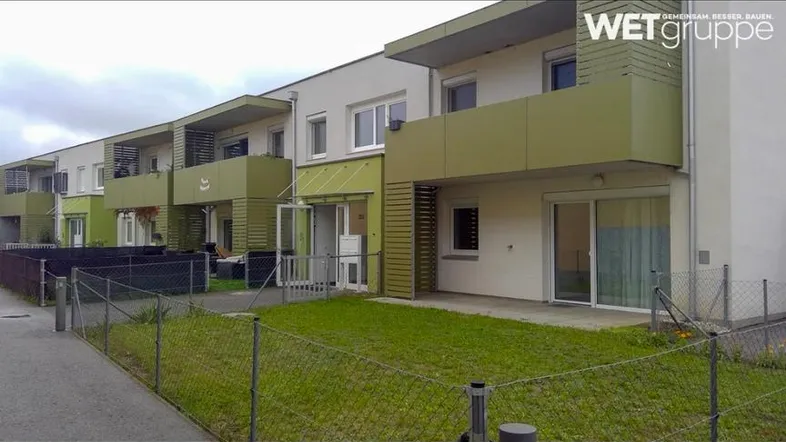 Moderne Wohnanlage mit mehreren Einheiten, Balkonen und gepflegten Grünflächen.