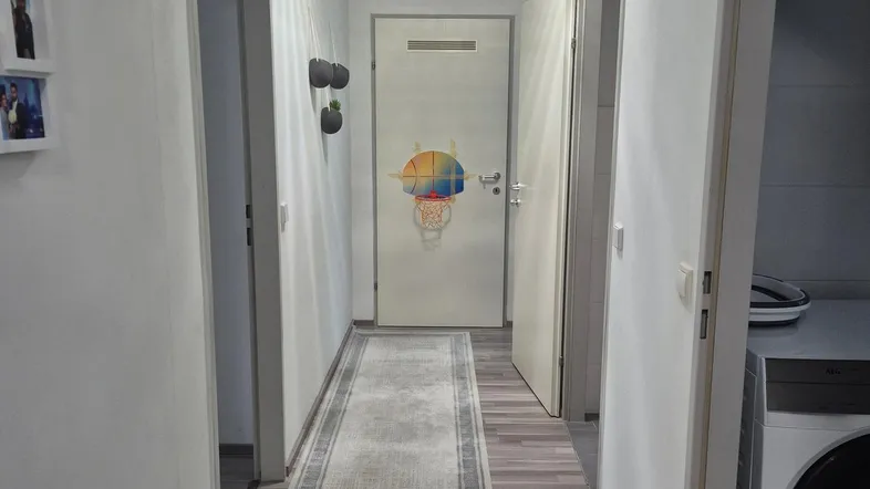 Heller Flur mit Laminatboden, Teppichläufer und Zugang zu verschiedenen Räumen.