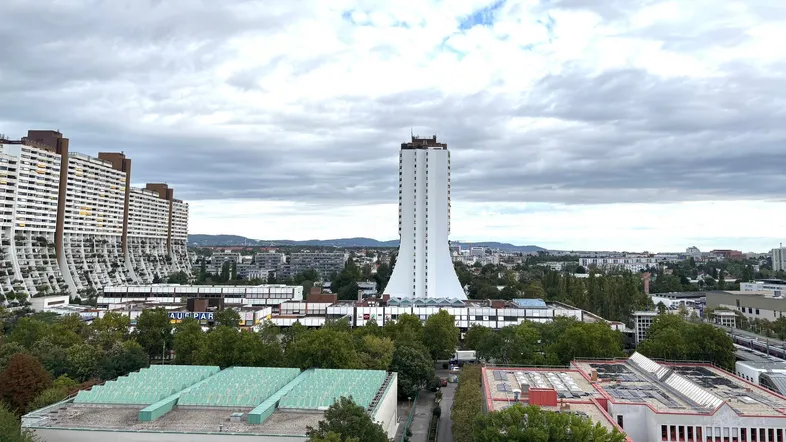 Panoramablick über die Stadt mit markanten Hochhäusern und bewölktem Himmel.