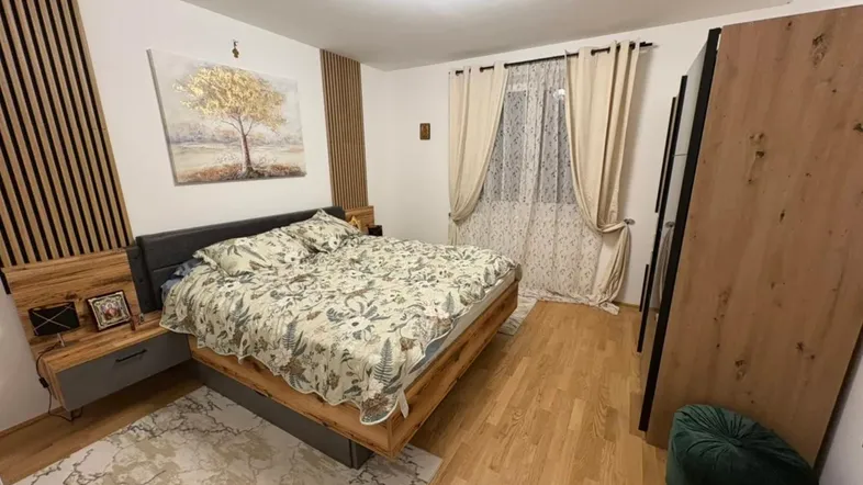 Modernes Schlafzimmer mit Holzbett, Parkettboden und dekorativen Wandpaneelen für eine gemütliche Atmosphäre.