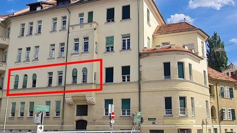 Außenansicht eines Mehrfamilienhauses mit klassischer Architektur und hervorgehobenen Fenstern.