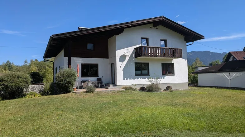 Freistehendes Haus mit Balkon, Terrasse und großem Garten in ländlicher Umgebung.