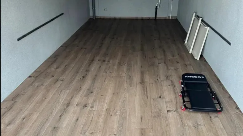 Geräumige Garage mit neuem Laminatboden, Waschbecken und hohen Decken.