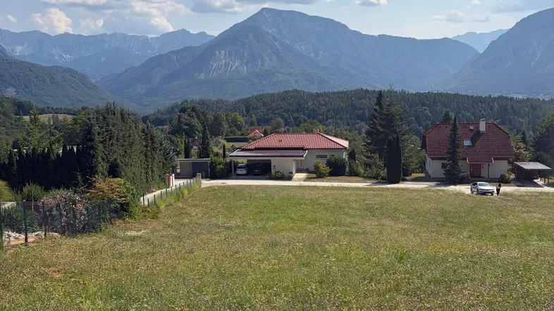 Weitläufiges Grundstück mit Bergblick und umliegender Natur unter blauem Himmel.