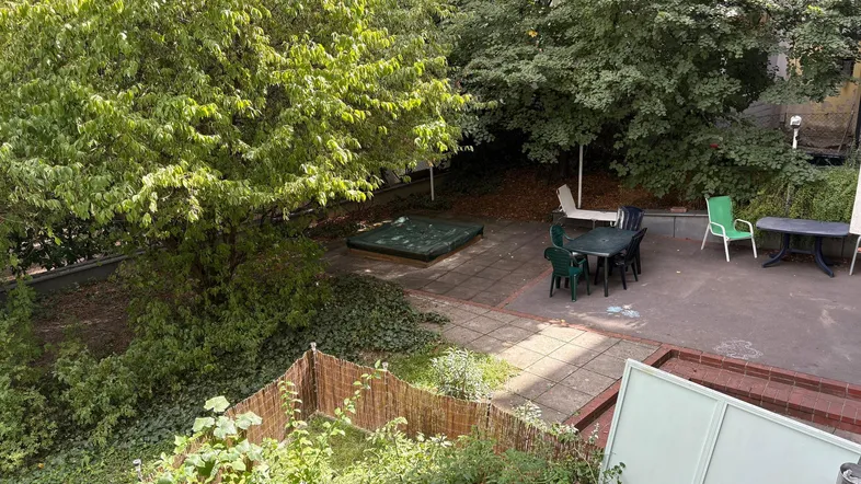 Geräumige Terrasse mit Sitzgelegenheiten und umgebendem Grün, ideal für entspannte Stunden im Freien.