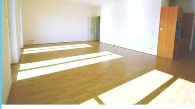 Helles und geräumiges Wohnzimmer mit Parkettboden und viel Tageslicht.