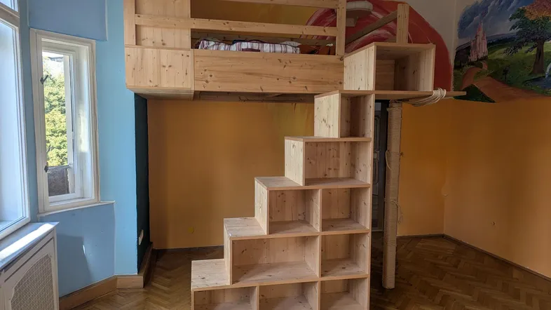 Kinderzimmer mit Hochbett und integrierter Treppe sowie Stauraum, ideal für kleine Räume.