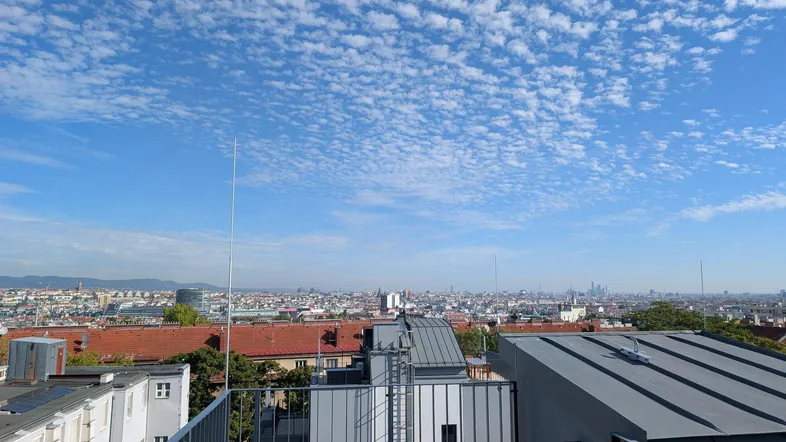 Panoramablick über die Stadt mit weitem Horizont und blauem Himmel an einem sonnigen Tag.