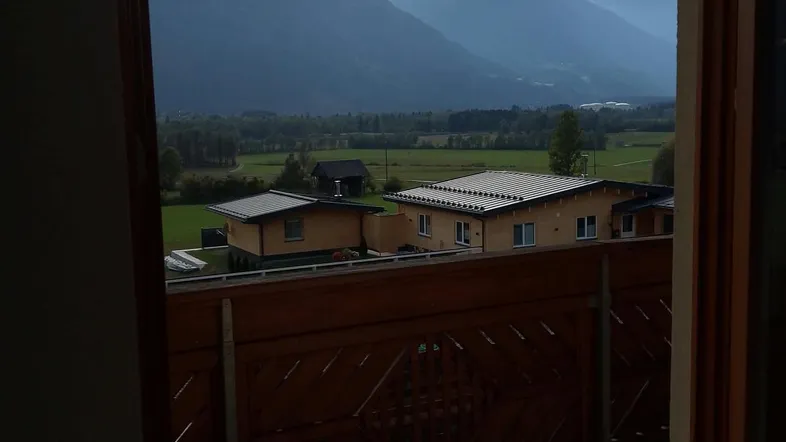 Geräumiger Balkon mit traditionellem Holzgeländer und weitem Blick auf die umliegende Berglandschaft.