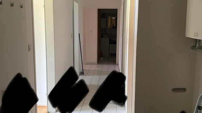 Heller Flur mit Fliesenboden und Garderobe, der zu weiteren Räumen führt.