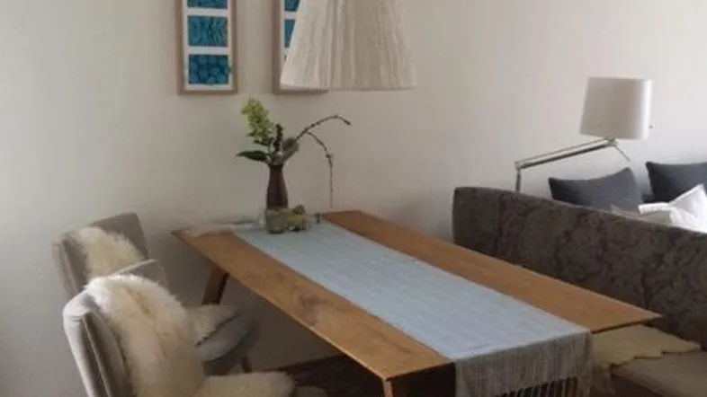 Heller Essbereich mit Holztisch, modernen Stühlen und dekorativen Elementen für eine gemütliche Atmosphäre.