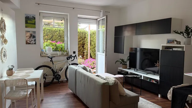 Helles Wohn- und Esszimmer mit Holzboden, moderner Einrichtung und Zugang zur Terrasse.