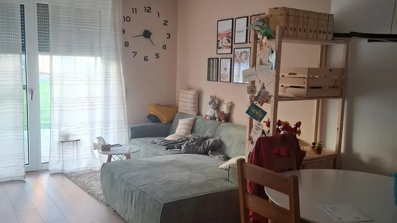 Heller Wohn- und Essbereich mit Sofa, Esstisch und Zugang zu einem Außenbereich.