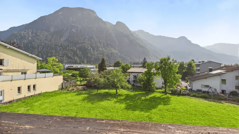 Panoramablick auf die umliegende Berglandschaft und grüne Wiesen von der Unterkunft aus.