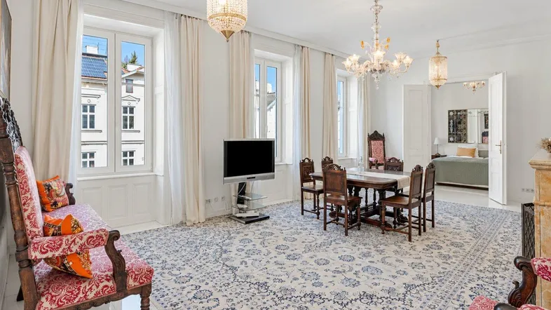 Geräumiger Wohn-Essbereich mit elegantem Teppich, Kronleuchtern und Blick auf die Stadt.