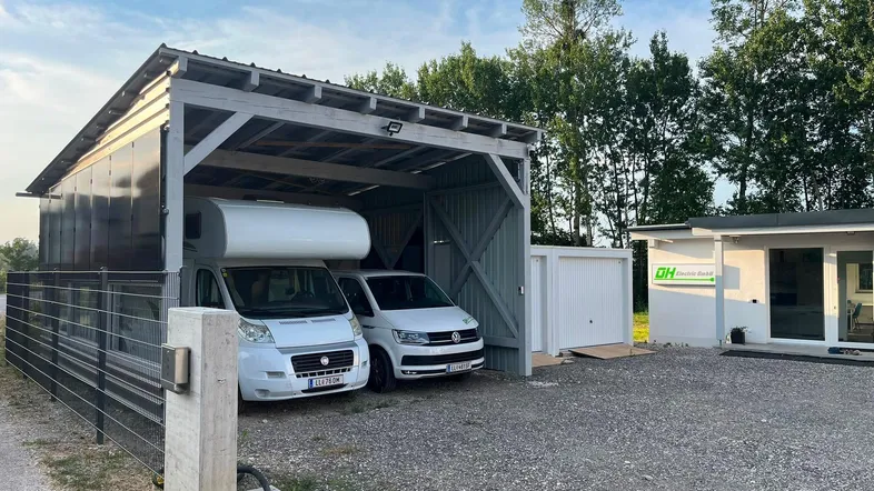 Moderner Carport mit Photovoltaikanlage bietet Platz für ein Wohnmobil und einen Transporter.