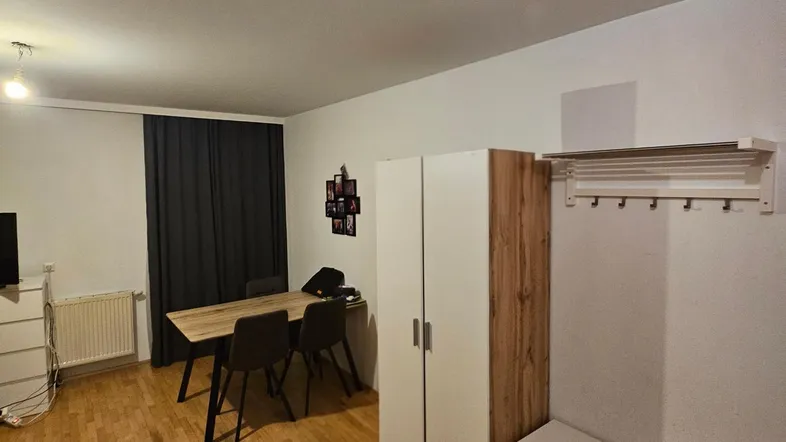 Heller Wohnbereich mit Holzboden, Esstisch und Stauraum, ideal für ein gemütliches Zuhause.