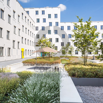 Zentrales Bürogebäude mit begrüntem Innenhof. combine Transaction