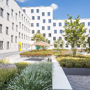 Zentrales Bürogebäude mit begrüntem Innenhof. combine Transaction