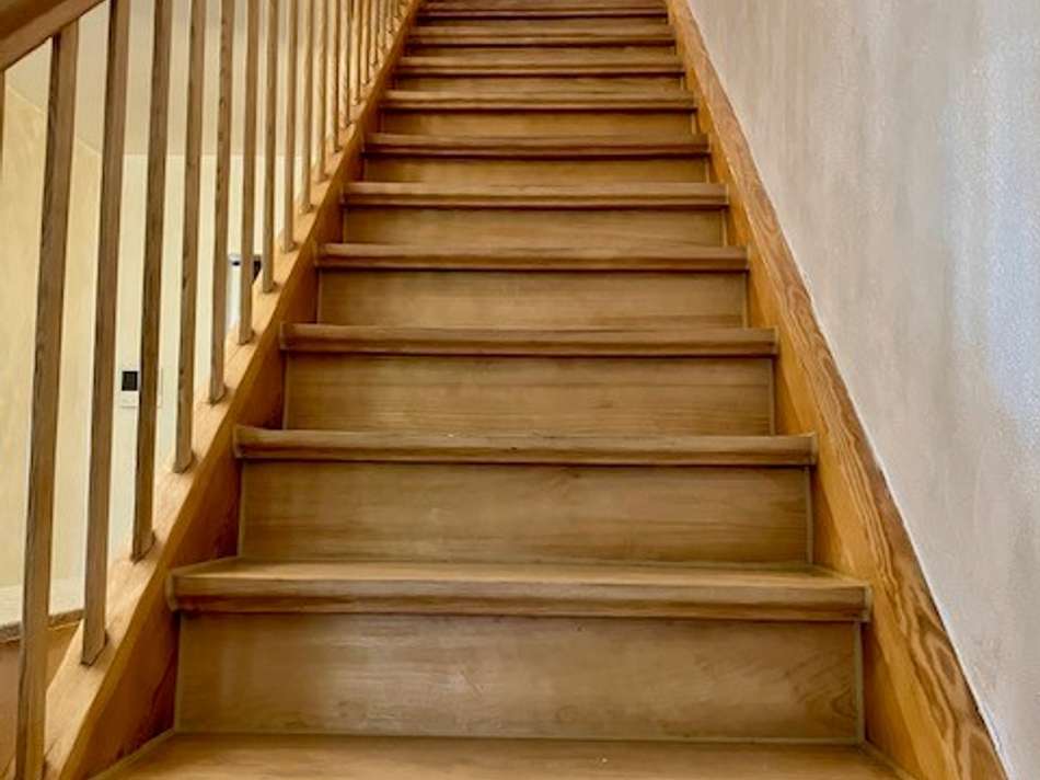Rustikale Vollholztreppe ins D