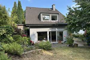 Wohnen im Grünen: Modernes Einfamilienhaus mit großem Garten, Carport und Split-Level-Architektur