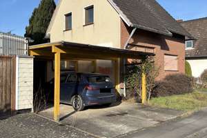 modernisierungsbedürftiges Einfamilienhaus mit Garage, Carport und großem Garten.