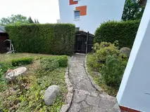 Gemütliches Reihenendhaus mit XL-Dachterrasse, Terrasse, Garten und zwei Garagen – Eingang zum Garten