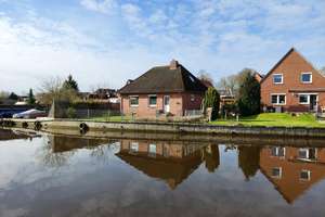 Ruhig und direkt am Wasser: renovierter 4-Zimmer-Bungalow in Loppersum, Hinte. Provisionsfrei! – Loppersumerstraße 24, 26759 Hinte – Vorschaubild 1