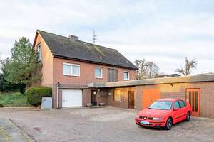Großzügiges Wohnhaus mit Garten, Garagen und Ackerland