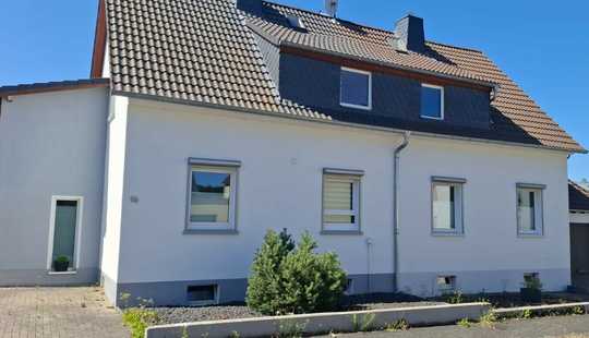 Bild von Großzügiges Einfamilienhaus mit vereinten Doppelhaushälften und Gartenidylle 