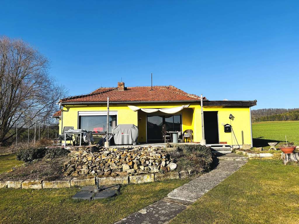 Immobilie in Hofheim in Unterfranken - Wohnen in absoluter Naturnähe! Walmdachbungalow mit Südterrasse, Nebengebäude, Carport auf einem  - Bild 4