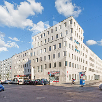 Zentrales Bürogebäude mit begrüntem Innenhof. combine Transaction