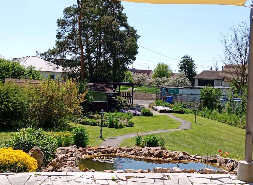 Immobilie in Hofheim in Unterfranken - Wohnen in absoluter Naturnähe! Walmdachbungalow mit Südterrasse, Nebengebäude, Carport auf einem  - Bild 2