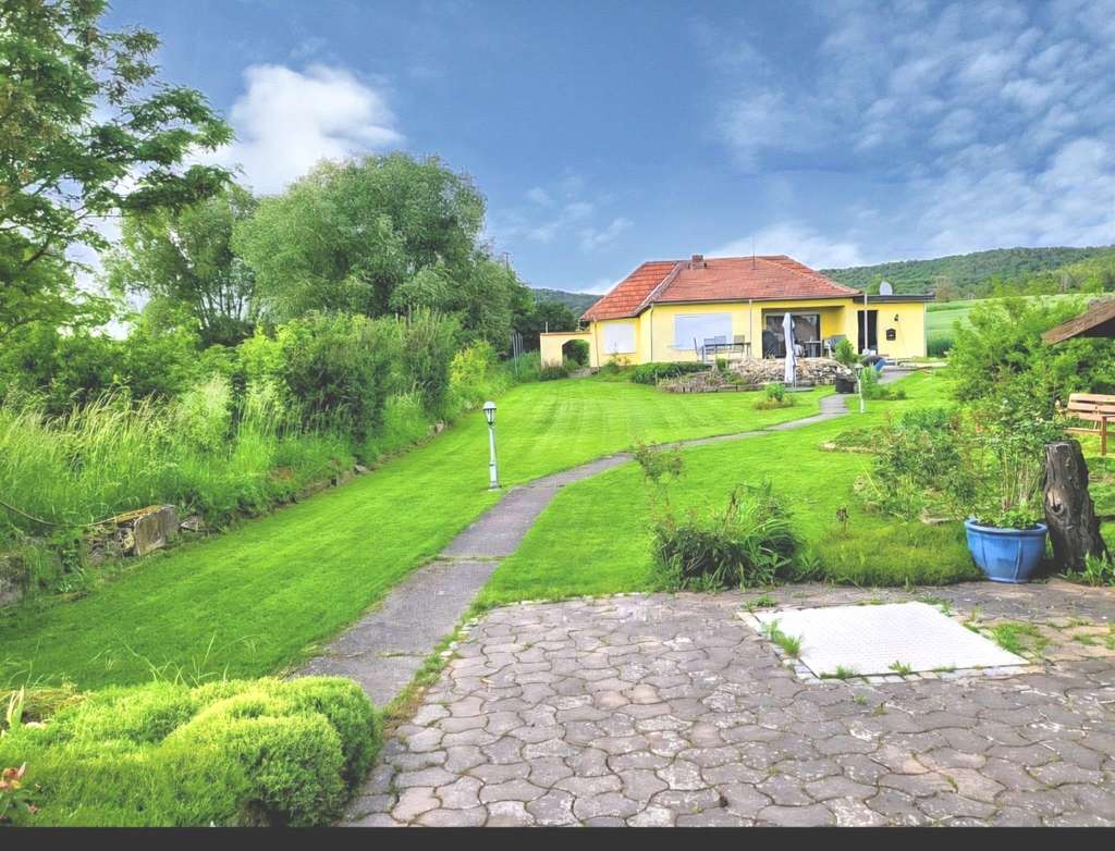 Immobilie in Hofheim in Unterfranken - Wohnen in absoluter Naturnähe! Walmdachbungalow mit Südterrasse, Nebengebäude, Carport auf einem  - Bild 0