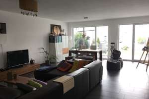 Moderne Wohnung mit überdachter Terrasse und kleinem Garten