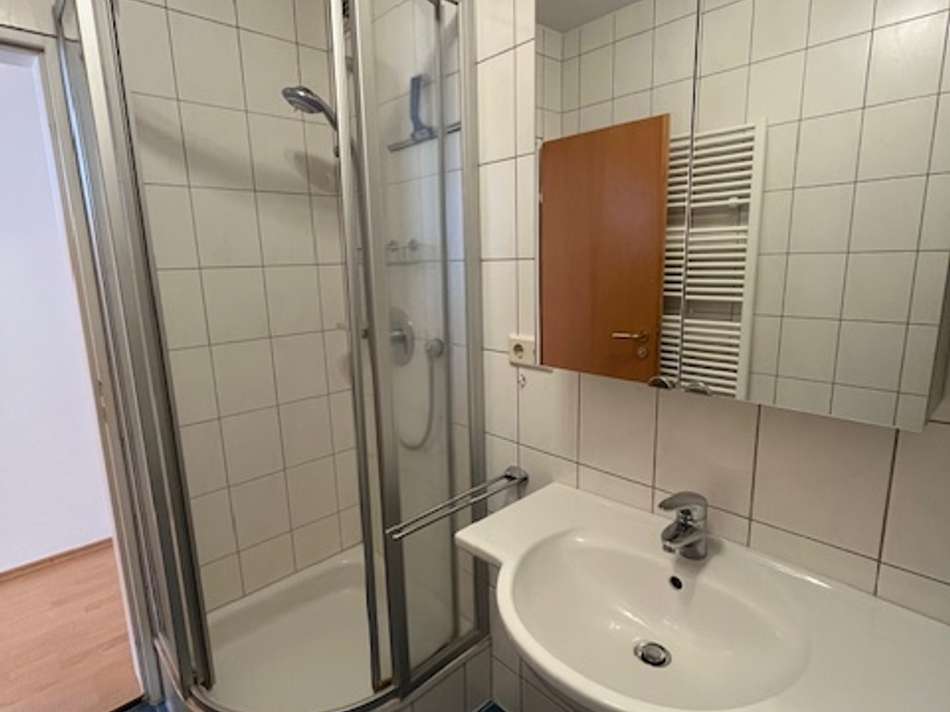 Dusche im hell gefliesten Bad